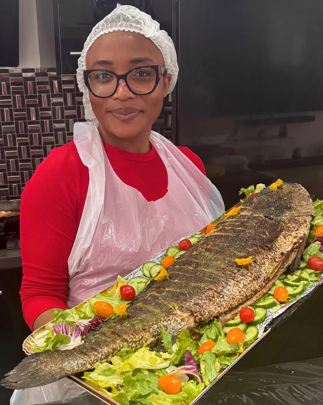 Pao présente un grand poisson braisé décoré de légumes